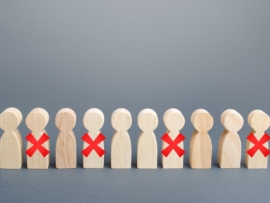 This photo illustrates employee layoffs using Xs over wooden figures.